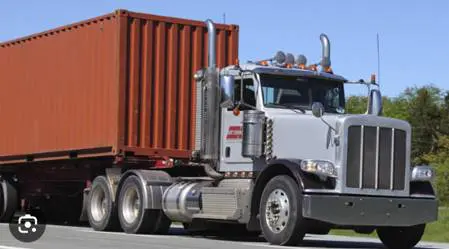 A large truck with a red trailer on the road.