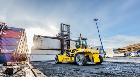 A yellow forklift is parked on the street.