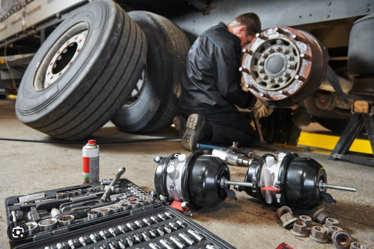 A man working on the wheels of an airplane.