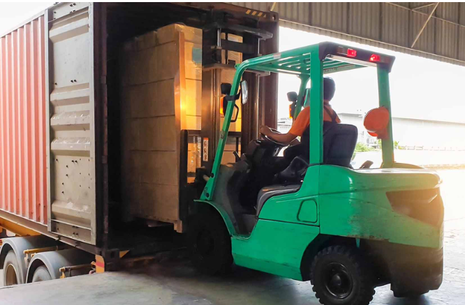 A forklift is loading boxes into the back of a truck.